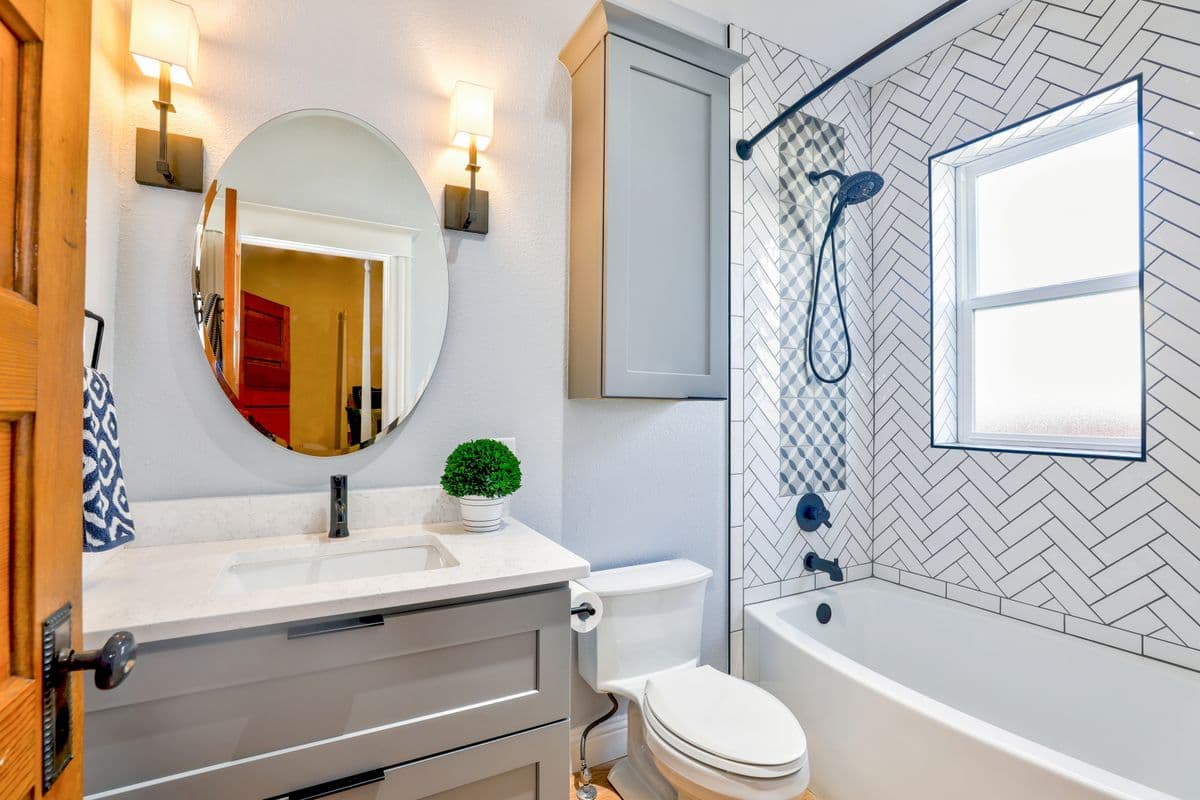 Bathroom with herringbone tile walls and a tub-shower combo