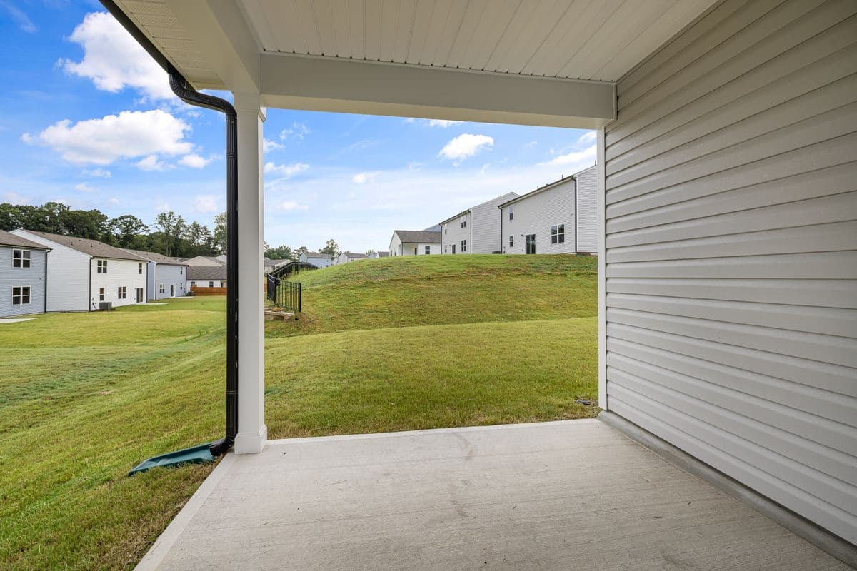 Covered concrete lanai off the back of a home overlooking an open backyard
