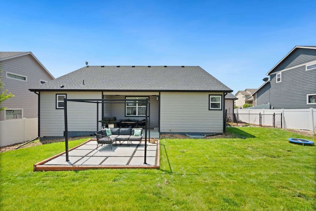 Backyard concrete patio with a new pergola and outdoor seating