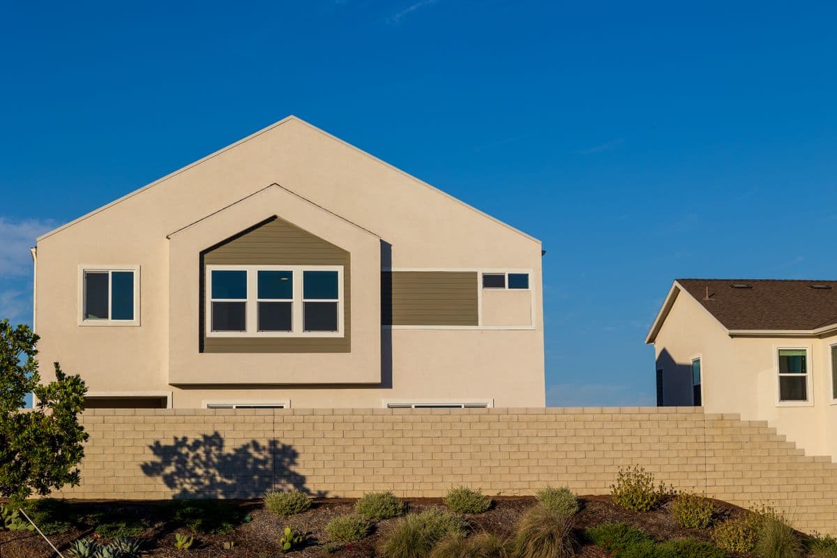 Two-story stucco home exterior with a fresh neutral repaint and new trim