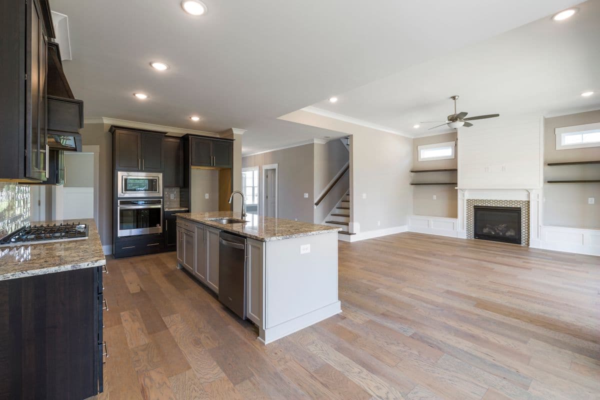 Open-concept kitchen and living area with a shiplap fireplace surround
