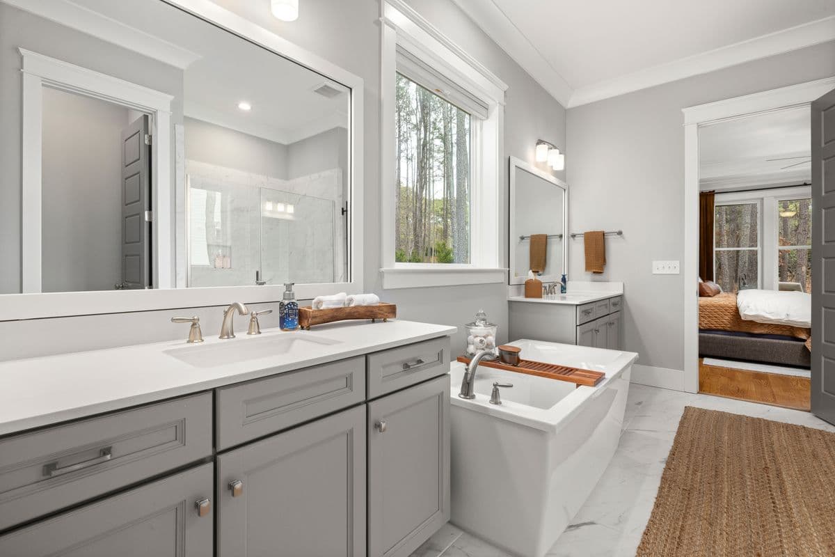 Master bathroom with dual vanity sinks and a freestanding soaking tub