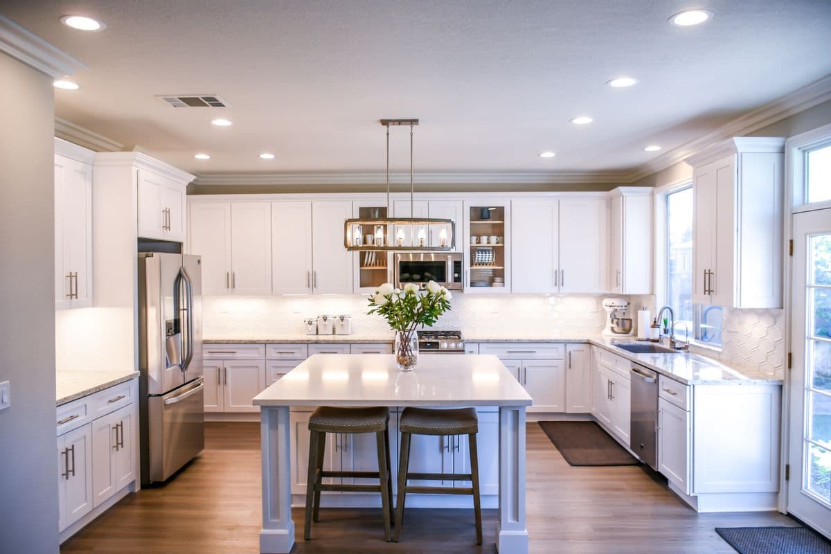 Bright white shaker kitchen with quartz countertops and stainless appliances