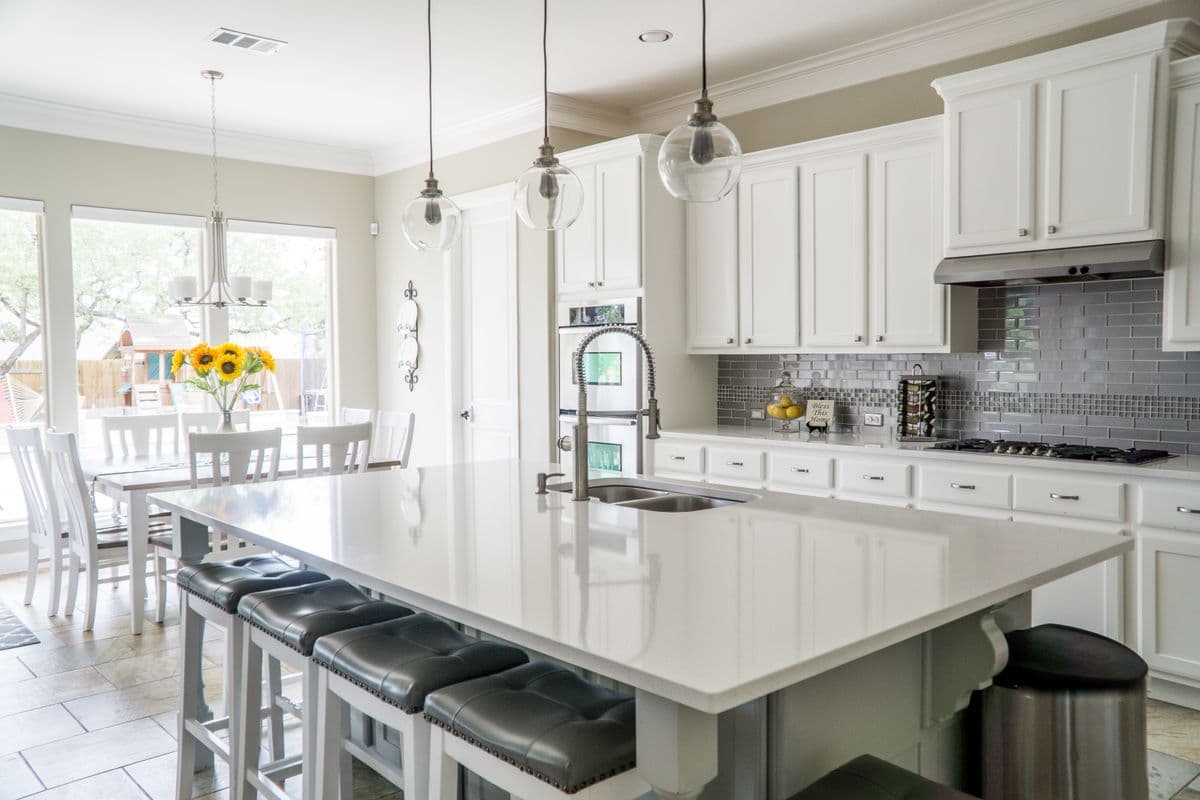 Bright white kitchen with a large island and pendant lighting